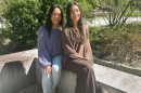 Leni and Michelle Lemos sit outside of the Peter T. Paul College of Business and Economics.