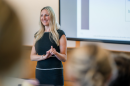 Kelly Root lectures in front of a classroom at Paul College.